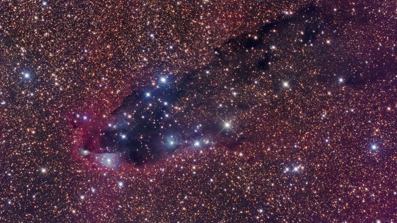 Em meio a um campo estelar lotado, na Constelação de Escorpião, esta nuvem cósmica e empoeirada evoca, para alguns, a imagem de uma sinistra torre escura. Aglomerados de poeira e gás molecular em colapso, formando estrelas, podem estar escondidos dentro desta nebulosa escura. A nuvem varrida para trás, que se estende do canto superior direito até a porção abaixo do centro, é moldada pela intensa radiação ultravioleta de estrelas muito quentes, vistas como pequenas nebulosas de reflexão azuladas. Esta torre escura, chamada de NGC 6231, e suas as nebulosas associadas estão a cerca de 5 mil anos-luz de distância da Terra