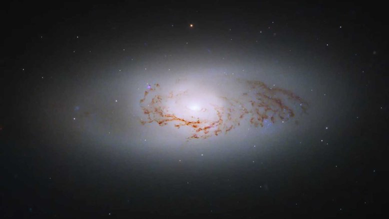 Galáxias lenticulares, como NGC 3489 desta imagem, não são exatamente galáxias espirais ou elípticas. Elas têm um bulbo central, um disco fino e circular de estrelas, gás e poeira - como galáxias espirais -, mas não possuem braços. E, como as galáxias elípticas, as galáxias lenticulares têm populações estelares mais antigas, com pouca formação estelar contínua. NGC 3489 tem um núcleo galáctico ativo, que emite radiação em todo o espectro eletromagnético, e está a cerca de 30 milhões de anos-luz de distância, na direção da Constelação de Leão