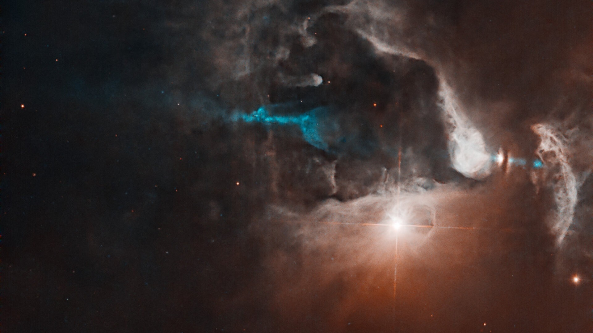 Jatos emergem do casulo de uma estrela recém-formada, cortando o gás e a poeira de uma nebulosa brilhante, nesta imagem. FS Tau é um sistema com diversas estrelas, especialmente FS Tau A, o objeto brilhante ao meio, e FS Tau B (Haro 6-5B), o objeto cintilante, na extrema direita, que está parcialmente obscurecido por uma faixa escura e vertical de poeira. O sistema tem apenas 2,8 milhões de anos, o que é muito jovem para um sistema estelar. FS Tau faz parte da região Taurus-Auriga, uma coleção de nuvens moleculares escuras que abrigam numerosas estrelas jovens e recém-formadas, a cerca de 450 anos-luz de distância, entre a Constelação de Touro e a Constelação de Auriga (“O Cocheiro”)