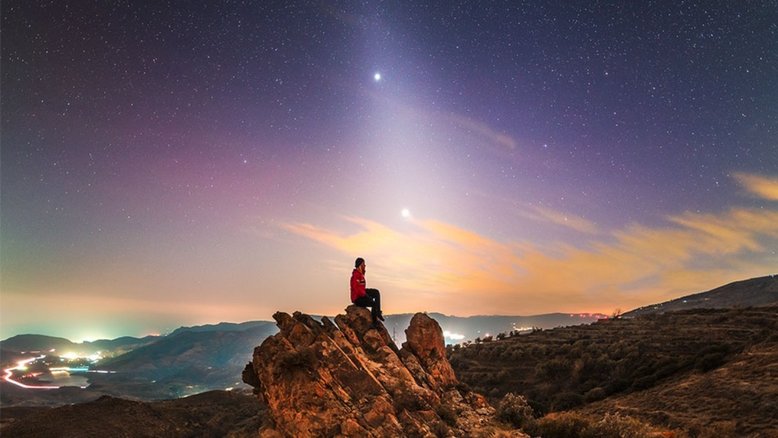 O que gera o raio de luz incomum que se estende pelo horizonte? Poeira orbitando o Sol! Em certas épocas do ano, uma faixa de poeira refletida pelo Sol, vinda do interior do Sistema Solar, aparece proeminentemente após o ocaso solar ou antes do amanhecer, chamada de luz zodiacal. A poeira foi emitida principalmente por cometas fracos da família de Júpiter e lentamente espirala em direção ao Sol. Esta imagem, registrada em fevereiro de 2023, no Parque Nacional de Sierra Nevada, na Espanha, captura a faixa brilhante de luz zodiacal junto aos brilhantes planetas Júpiter (acima) e Vênus (abaixo)