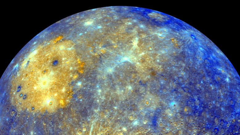 Este espetacular mosaico colorido mostra o extremo Leste de Mercúrio, visto pela espaçonave Messenger, quando ela partiu do planeta após o seu primeiro sobrevoo, em janeiro de 2008. As cores desta imagem não são aquelas que seriam vistas pelo olho humano, mas transmitem informações sobre a distribuição de diferentes tipos de rochas na superfície do planeta. A bacia Caloris, visível como uma grande área circular amarela e brilhante devido às suas planícies vulcânicas, domina a região Norte