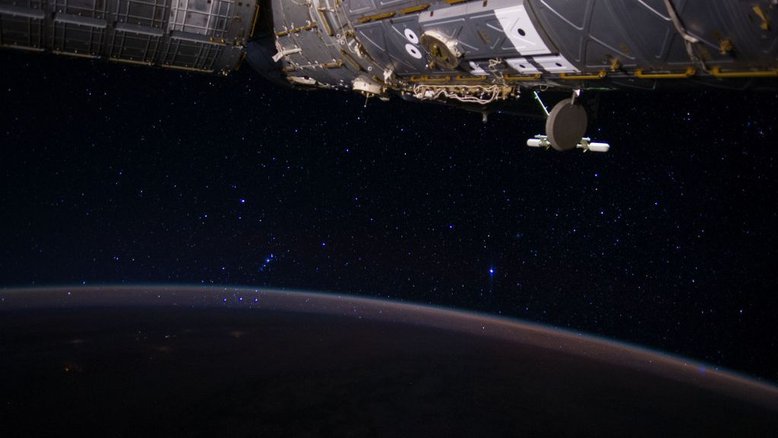 A Constelação de Órion é o destaque desta imagem. O Cinturão de Órion, popularmente conhecido como “As Três Marias”, se destaca próximo ao horizonte, visto através da atmosfera da Terra, neste registro feito a bordo da Estação Espacial Internacional (ISS). As estrelas do cinturão - Alnitak, Alnilam e Mintaka - estão alinhadas, da direita para a esquerda, e a espada de Órion, lar da grande Nebulosa de Órion, parece pendurada acima do seu cinturão, já que o famoso caçador aparentemente está invertido em relação à sua orientação habitual no céu do Hemisfério Norte do planeta. Isso coloca a estrela brilhante Rigel, que marca o pé de Órion, ainda mais acima em relação ao cinturão. A estrela mais brilhante na imagem é Sirius, estrela Alfa da Constelação do Cão Maior. O módulo Destiny Laboratory, da ISS, está em primeiro plano, no canto superior direito