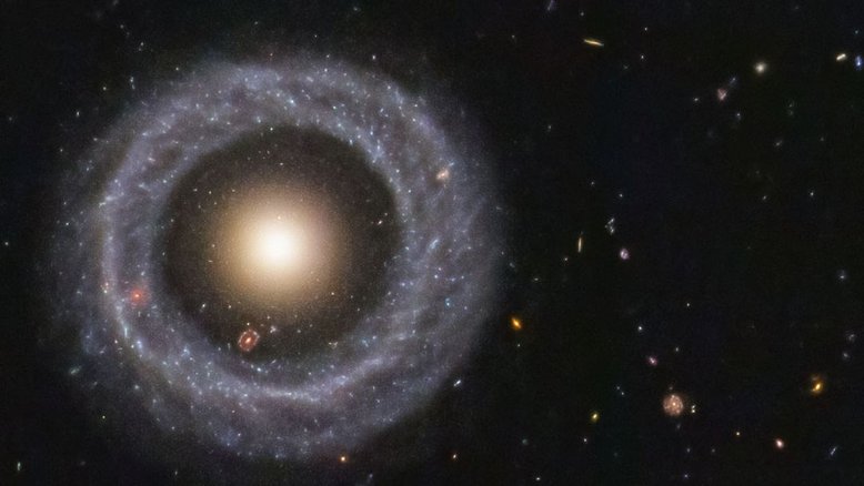 Esta é uma galáxia ou duas? Essa questão veio à tona em 1950, quando o astrônomo Arthur Hoag encontrou por acaso este objeto extragaláctico incomum. Do lado de fora há um anel dominado por estrelas azuis brilhantes, enquanto perto do centro há uma bola de estrelas muito mais vermelhas, que provavelmente são muito mais antigas. Entre os dois existe uma lacuna que parece quase completamente escura. Por isso, essa estrutura recebeu o nome de Objeto de Hoag, mas como ele se formou ainda permanece desconhecido. Este Objeto de Hoag fica a cerca de 600 milhões de anos-luz de distância, na direção da Constelação de Serpens (“A Serpente”)