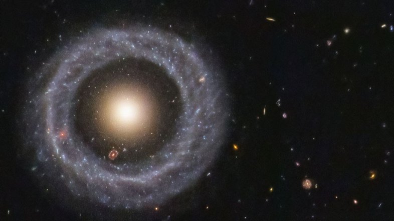 Esta é uma galáxia ou duas? Essa questão veio à tona em 1950, quando o astrônomo Arthur Hoag encontrou por acaso este objeto extragaláctico incomum. Do lado de fora há um anel dominado por estrelas azuis brilhantes, enquanto perto do centro há uma bola de estrelas muito mais vermelhas, que provavelmente são muito mais antigas. Entre os dois existe uma lacuna que parece quase completamente escura. Por isso, essa estrutura recebeu o nome de Objeto de Hoag, mas como ele se formou ainda permanece desconhecido. Este Objeto de Hoag fica a cerca de 600 milhões de anos-luz de distância, na direção da Constelação de Serpens (“A Serpente”)