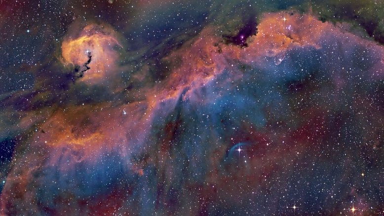 Uma vasta extensão de gás e poeira que se assemelha a um pássaro e, assim, foi apelidada de Nebulosa da Gaivota. Este mosaico de 3 painéis do pássaro cósmico cobre uma faixa ampla, no plano da Via Láctea, perto da direção de Sirius, a estrela Alfa da Constelação do Cão Maior. Parte da estrutura de concha varrida por sucessivas explosões de supernovas, a ampla Nebulosa da Gaivota foi catalogada como Sh2-296 e IC 2177. O arco azulado, abaixo e à direita do centro, circunda a estrela FN Canis Majoris. Este complexo de nuvens, junto a outras estrelas da associação Canis Majoris OB1, se estende por mais de 200 anos-luz e fica a uma distância estimada de 3,8 mil anos-luz