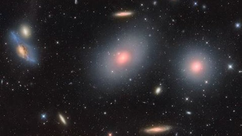 O Aglomerado de Galáxias de Virgem é o conjunto de galáxias mais próximo da Via Láctea. Com o seu centro a cerca de 70 milhões de anos-luz de distância, o Aglomerado de Virgem contém mais de 2 mil galáxias, mantendo uma atração gravitacional notável sobre as galáxias do Grupo Local, do qual faz parte a nossa galáxia. O aglomerado contém não apenas galáxias, mas também gás quente, que brilha em raios X. Os movimentos das galáxias indicam que os aglomerados contém mais matéria escura do que qualquer matéria visível. Retratado aqui, o coração do Aglomerado de Virgem, que fica na direção da Constelação de Virgem, inclui galáxias como a conhecida como “Olhos de Markarian”, no canto superior esquerdo; M86, no canto superior direito do centro; M84, na extrema direita, e a galáxia espiral NGC 4388, no canto inferior direito