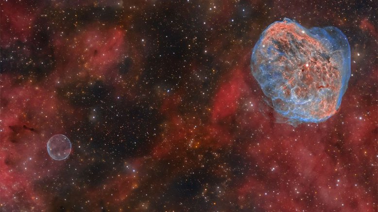 Duas nuvens estelares mortais, de gás e poeira, podem ser encontradas em direção à Constelação do Cisne. Nesta imagem, estão a Nebulosa Bolha de Sabão (canto inferior esquerdo) e a Nebulosa Crescente (canto superior direito). Também conhecida como NGC 6888, a Nebulosa Crescente foi moldada à medida que a sua brilhante e massiva estrela Wolf-Rayet central, WR 136, se desfez do seu envelope exterior num forte vento estelar. WR 136 está perto do fim de uma vida curta, que deverá terminar em uma supernova. A Nebulosa da Bolha de Sabão é provavelmente uma nebulosa planetária, o envoltório final de uma estrela semelhante ao Sol. Ambas as nebulosas estão a cerca de 5 mil anos-luz de distância
