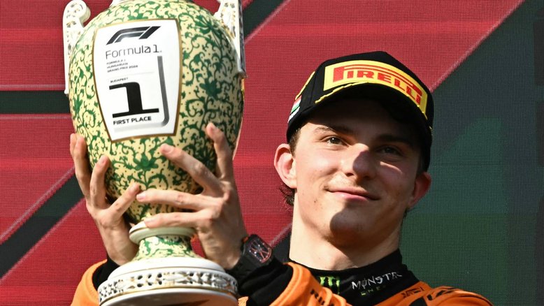 Winner Team McLaren-Mercedes' Oscar Piastri celebrates on the podium with the trophy after the Formula One Hungarian Grand Prix at the Hungaroring race track in Mogyorod near Budapest on July 21, 2024. (Photo by Attila KISBENEDEK / AFP)