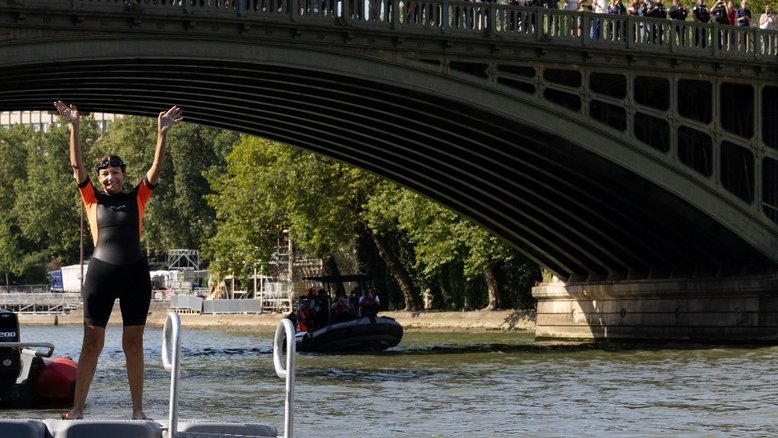 A prefeita de Paris, Anne Hidalgo, acena antes de nadar no Sena, em Paris, em 17 de julho de 2024, para demonstrar que o rio está limpo o suficiente para sediar os eventos de natação ao ar livre nas Olimpíadas de Paris