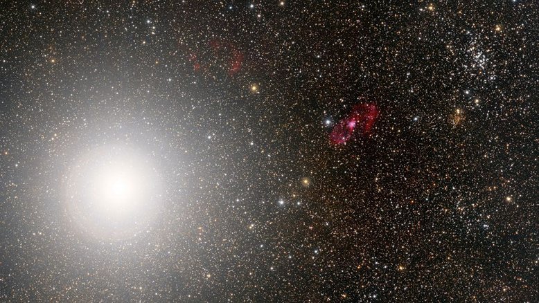 Alpha Centauri, uma das estrelas mais brilhantes do céu noturno na Terra, inunda o lado esquerdo desta paisagem celeste meridional. A apenas 4,3 anos-luz de distância, Alpha Centauri consiste, na verdade, em duas estrelas semelhantes em tamanho ao Sol, presas gravitacionalmente em uma órbita mútua. Um terceiro membro do mesmo sistema estelar, Próxima Centauri, encontra-se fora deste campo de visão. A cena telescópica também inclui a nebulosa planetária catalogada como Hen 2-111, a cerca de 7,8 mil anos-luz de distância. Mais à direita, estão dois notáveis ​​aglomerados abertos de estrelas, o compacto Pismis 19, a quase 8 mil anos-luz de distância e o mais solto e próximo NGC 5617