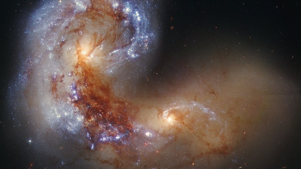 NGC 4038 já foi uma galáxia espiral normal até NGC 4039, à sua direita, colidiu com ela. Os destroços em evolução são mostrados acima. À medida que a gravidade reestrutura cada galáxia, nuvens de gás colidem umas com as outras, formando nós azuis brilhantes de estrelas. No futuro, as duas galáxias convergirão em uma galáxia espiral maior. Essa dupla em colisão está localizada a cerca de 45 milhões de anos-luz de distância, na Constelação do Corvo