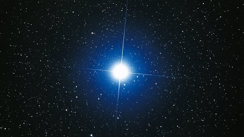 Esta imagem, feita a partir do solo, aqui na Terra, foi tirada pelo astrônomo Akira Fujii e mostra Sirius, a estrela Alfa da Constelação do Cão Maior. Na verdade, Sirius é uma estrela dupla, ou seja, é formada por duas estrelas que interagem gravitacionalmente. Sirius A é a estrela mais brilhante do céu noturno, mas junto dela está uma pequena e fraca companheira estelar, Sírius B. As duas estrelas giram em torno uma da outra a cada 50 anos. Sirius A, a apenas 8,6 anos-luz da Terra, é o quinto sistema estelar mais próximo conhecido. Sirius B, uma anã branca, é muito tênue devido ao seu pequeno tamanho, sendo também cerca de 10 mil vezes mais fraca do que a Sirius A