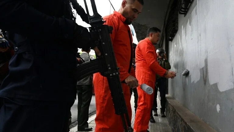 Homens da Polícia Militar de Ordem Pública vigiam membros de gangues presos que faziam pichações em Tegucigalpa, Honduras, em 8 de julho de 2024 - AFP/Arquivos
