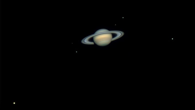 Nesta imagem, vê-se um nítido retrato de família de Saturno e algumas de suas luas. Maior que a Lua da Terra e até um pouco maior que Mercúrio, Titã está na parte inferior esquerda. Mais à direita, estão Mimas, Tétis, Encélado, Dione e Rhea, na extrema direita. O primeiro satélite natural conhecido de Saturno, Titã, foi descoberto em 1655 pelo astrônomo holandês Christiaan Huygens. Esses dias, Saturno está próximo à sua oposição no céu da Terra, oferecendo as melhores vistas telescópicas do planeta e suas luas