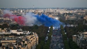Esta fotografia tirada do Arco do Triunfo mostra fumaça com o caldeirão Paraolímpico com o Obelisco de Louxor (Obelisco de Luxor) na frente e o museu do Louvre na parte de trás antes da Cerimônia de Abertura dos Jogos Paraolímpicos de Paris 2024 em Paris em 28 de agosto de 2024. Martin BUREAU/AFP