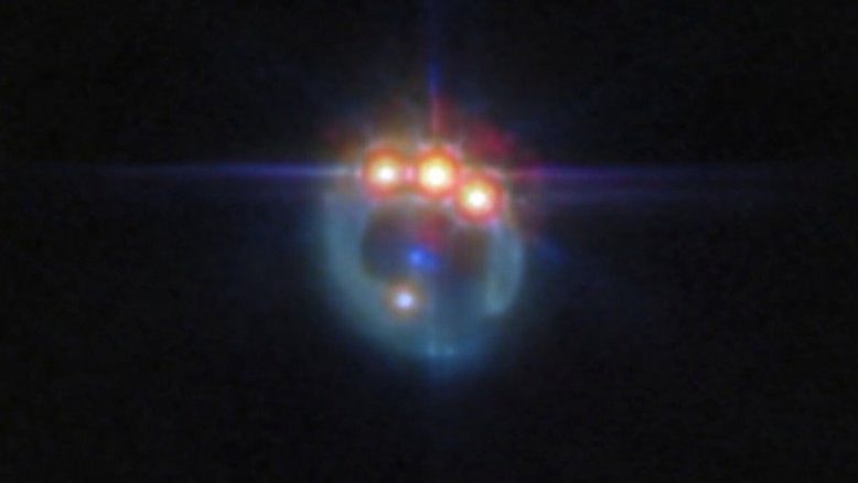 Esta imagem, feita pelo Telescópio Espacial James Webb, apresenta a lente gravitacional do quasar conhecido como RX J1131-1231, localizado a cerca de 6 bilhões de anos-luz da Terra, na Constelação de Crater. Nele, a galáxia em primeiro plano mancha a imagem do quasar de fundo, em um arco brilhante, e cria quatro imagens do objeto. As lentes gravitacionais, conforme descreve a teoria da relatividade, de Albert Einstein, agem como telescópios naturais, pois ampliam a luz. O fenômeno reflete o fato de que toda a matéria no Universo distorce o espaço ao seu redor. Assim, em volta de objetos muito massivos, a luz parece se curvar de seu caminho original