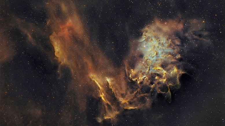 Embora AE Aurigae e sua nebulosa circundante, IC 405, formem o que se tornou conhecido pelo nome de Nebulosa da Estrela Flamejante, não há fogo no local. O material que aparece como fumaça é composto por hidrogênio interestelar e filamentos escuros ricos em carbono. A estrela brilhante AE Aurigae, visível à direita, é tão quente que afasta os elétrons do gás circundante. Quando um próton recaptura um elétron, a luz é emitida. A Nebulosa da Estrela Flamejante fica a cerca de 1,5 mil anos-luz de distância, na direção da Constelação de Auriga (“O Cocheiro”)