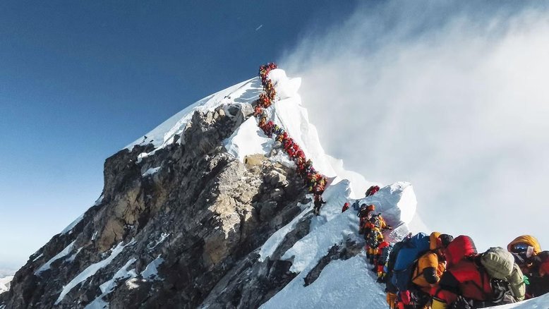 Pessoas em fila escalam montanha gelada