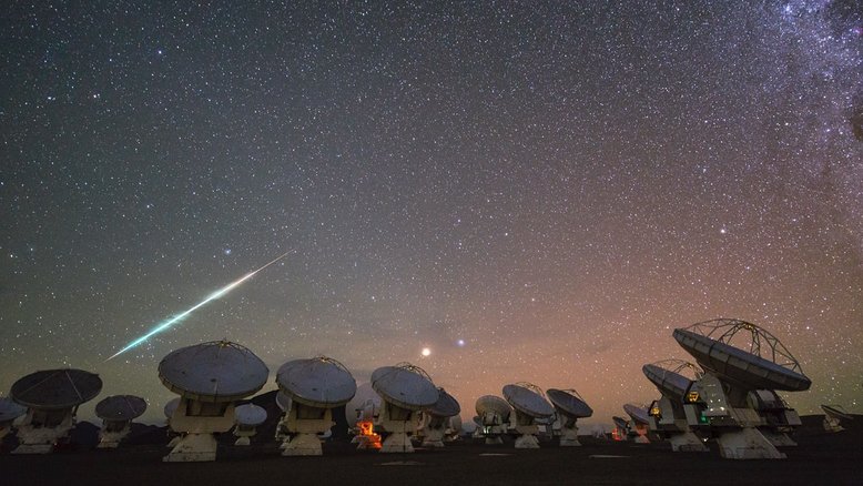 Esta imagem mostra o observatório do Atacama Large Millimeter/submillimeter Array (ALMA). Localizado a 5 mil metros acima do nível do mar, no planalto do Chajnantor, nos Andes chilenos, ele tem 66 antenas de alta precisão para estudar o espaço interestelar. O dardo de luz sobre a rede do ALMA é um meteoro que queima ao entrar na atmosfera da Terra. A estrela Alfa e mais brilhante da Constelação de Virgem, a azulada Spica, e o avermelhado planeta Marte brilham intensamente no centro da imagem