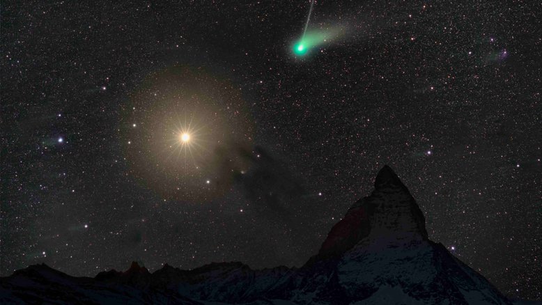 Apelidado de Cometa Verde pela cor de sua cabeleira brilhante, o cometa C/2022 E3 (ZTF) passou quase na frente do planeta Marte, em fevereiro de 2023. Os dois aparecem neste registro do céu, feito junto a Matterhorn, uma montanha nos Alpes, entre a Suíça e a Itália. A cauda de poeira branca do cometa está visível à direita da cabeleira verde, enquanto a cauda de íon azul claro segue em direção ao topo da imagem. O alaranjado planeta Marte brilha próximo à nebulosa escura Barnard 22, abaixo e à direita