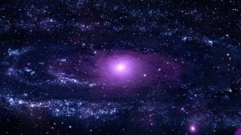 A famosa Galáxia de Andrômeda, também conhecida como M31, leva o nome de sua constelação hospedeira, a Constelação de Andrômeda. Localizada a 2,5 milhões de anos-luz de distância, esta vasta espiral estrelada é a galáxia espiral mais próxima à nossa Via Láctea. Imagens em luz ultravioleta revelam aglomerados densos de estrelas jovens e quentes, especialmente abundantes em um enorme anel com cerca de 150 mil anos-luz de diâmetro. Assim como na nossa galáxia, o disco e os braços espirais da M31 contêm a maior parte do gás e da poeira necessários para produzir novas gerações de estrelas