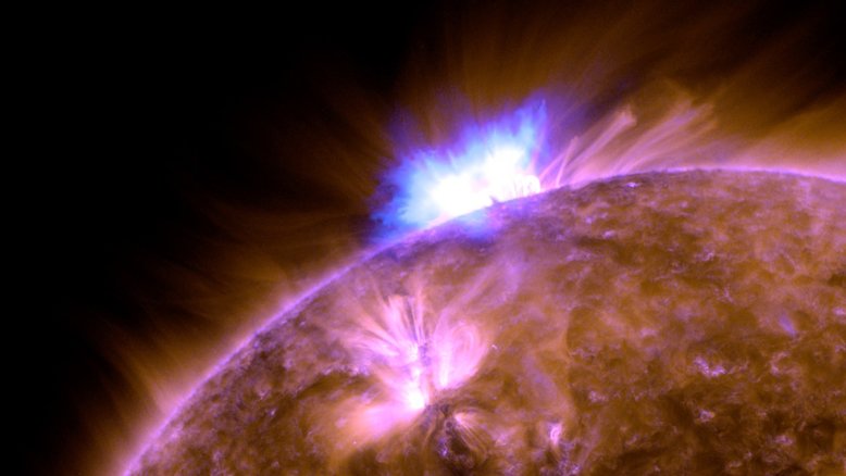Esta imagem mostra uma erupção solar que ocorreu no Sol, em novembro de 2020. Também visível está uma erupção de material solar que se moveu para o espaço como uma nuvem gigante de gás e campos magnéticos, conhecida como ejeção de massa coronal. Uma característica invisível desses eventos é o enxame de partículas energéticas que são guiadas pelos campos magnéticos que fluem do Sol. Devido à rotação constante da estrela central do Sistema Solar, elas apontam para trás em uma grande espiral. As partículas viajaram ao longo dessa espiral magnética para longe da Terra, em direção ao outro lado do Sol