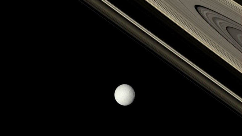 Qual a idade dos anéis de Saturno? Ninguém sabe ao certo. Uma possibilidade é que os anéis se formaram recentemente na história do nosso Sistema Solar, há apenas cerca de 100 milhões de anos, quando um objeto do tamanho de uma lua se despedaçou perto de Saturno. Evidências mais recentes, no entanto, levantam a possibilidade de que alguns dos anéis podem ter bilhões de anos e, portanto, serem tão antigos quanto o próprio planeta. Nesta imagem, os anéis de Saturno foram fotografados em suas cores verdadeiras pela sonda robótica Cassini. A brilhante e gelada Tétis, uma das luas de Saturno, aparece em primeiro plano, iluminada provavelmente por um jato de gelo vindo de sua lua irmã, Encélado