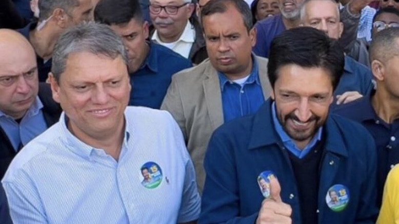 Tarcísio de Freitas (Republicanos) e Ricardo Nunes (MDB) são seguidos, ao fundo, pelo capitão da PM Cangerana | Reprodução/X