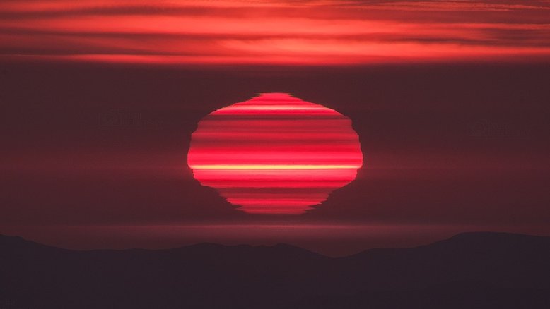 Em janeiro de 2017, este pôr do Sol foi digno de ser registrado. Aparentemente fatiado em muitas camadas horizontais, o Sol brilhou momentos antes de tocar o horizonte, pondo-se sobre o Oceano Pacífico, visto do topo da montanha do Observatório Las Campanas, no Chile. Tons rosados ​​de luz solar filtrada foram criados pela longa linha de visão através da atmosfera nebulosa. Mas as listas ​​correspondem a camadas atmosféricas baixas de temperatura e densidade diferentes. Ao longo do caminho através de cada camada, os raios de luz solar são refratados, criando miragens de seções do Sol no poente (Foto: Yuri Beletsky)