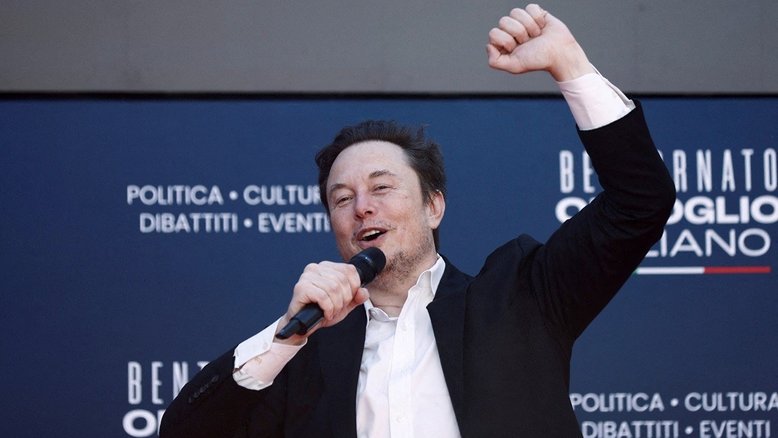Elon Musk celebra sorridente com um braço para o alto
