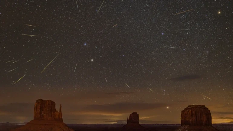O presente anual do asteroide 3200 Phaethon à Terra pode ser visto entre as estrelas da Constelação de Gêmeos. Conhecido como chuva de meteoros Geminídeos, a fonte do fluxo de meteoros é a poeira derramada ao longo da órbita do misterioso asteroide. Perto do pico de atividade da chuva, meteoros geminídeos foram capturados nesta paisagem noturna sobre o Monument Valley, no sudoeste americano. As estrelas brilhantes perto da posição do radiante da chuva são as duas estrelas principais da Constelação de Gêmeos, Castor (azul) e Pollux (amarelo)