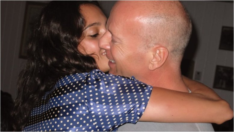 Fotografia de Emma e Bruce Willis abraçando-se e beijando-se