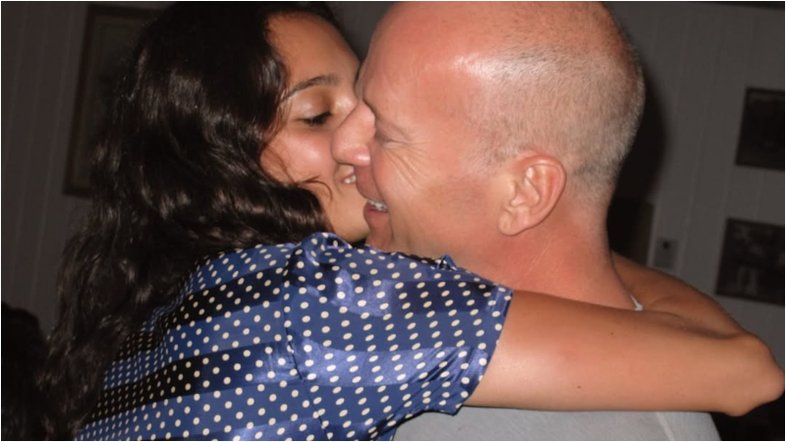 Fotografia de Emma e Bruce Willis abraçando-se e beijando-se