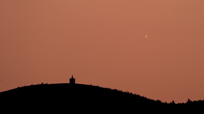 Esta não é uma imagem da Lua! O que aparece acima das colinas, no horizonte Oeste e próximo ao pôr do Sol, é o planeta Vênus, em sua fase menos iluminada. A cerca de 54 milhões de quilômetros de distância e com menos de 20% de iluminação, o planeta foi capturado ao final de setembro de 2018, perto de Bacau, na Romênia. Nesse período, o mais brilhante entre os planetas passou a se despedir da fase como Estrela Vespertina. Dirigindo-se para uma conjunção inferior, o planeta ficou posicionado entre a Terra e o Sol, o que o tornou ausente do céu noturno. No mês de outubro subsequente, Vênus reapareceu ao Leste, nascendo pouco antes do Sol, como a brilhante Estrela da Manhã