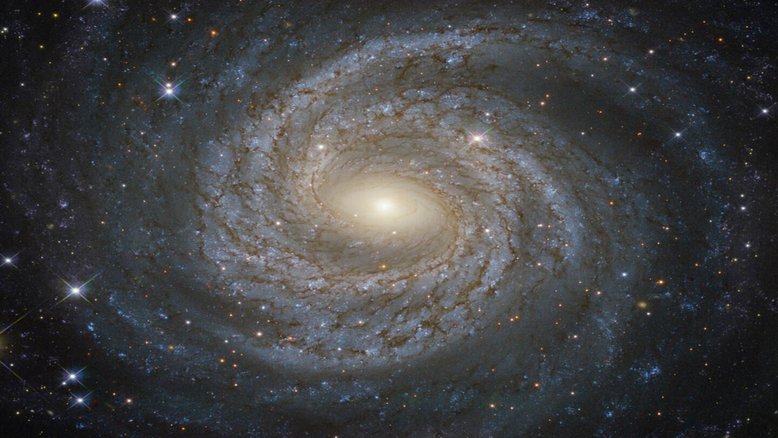 No centro deste redemoinho estelar, há um buraco negro que varre bilhões de estrelas, com destaque para as mais brilhantes e azuis. A amplitude e o formato do redemoinho dão a ele a designação de uma galáxia espiral de grande design. O seu buraco negro supermassivo tem cerca de 10 milhões de vezes a massa do nosso Sol. Ele devora estrelas e gás, sendo cercado por um fosso giratório de plasma quente que emite rajadas de raios-X. A atividade violenta também coloca esta galáxia dentre as do tipo Seyfert. Catalogada como NGC 6814, esta galáxia fica a cerca de 75 milhões de anos-luz de distância, na direção da Constelação da Águia