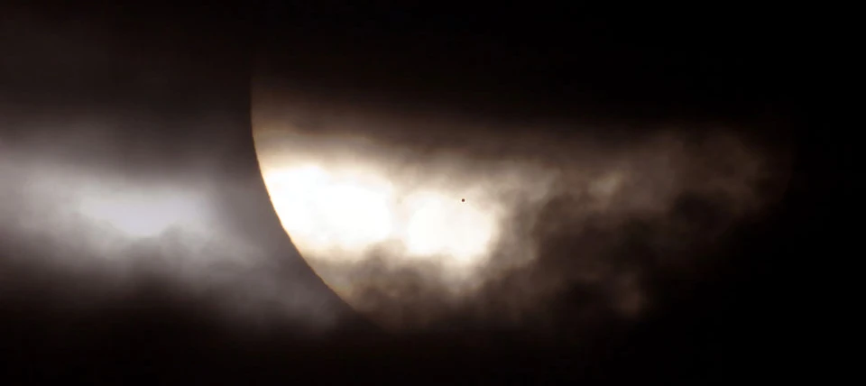 O que é aquele ponto no Sol? É Mercúrio. Assim como a aproximação da Lua Nova antes de um eclipse solar, nesta imagem, a fase de Mercúrio tornou-se um crescente cada vez mais fino à medida que o planeta progredia em direção a um alinhamento com o Sol. Posteriormente, o percentual de iluminação de Mercúrio caiu para zero e a mancha escura do planeta cruzou a frente da estrela central do Sistema Solar. A situação poderia tecnicamente ser rotulada como um eclipse anular de Mercúrio, mas com com um anel de fogo solar extraordinariamente grande