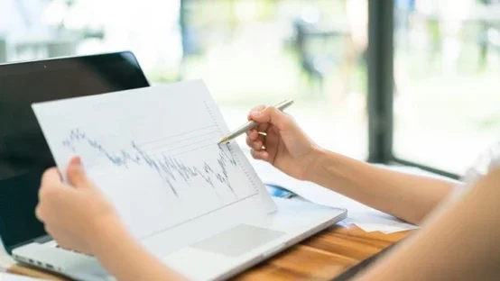 Business people using laptop and Financial charts at meeting off