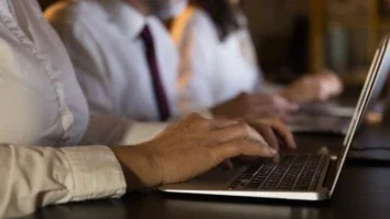 Partial view of business people using laptops