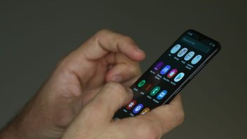 Pessoa mexe no celular com as duas mãos