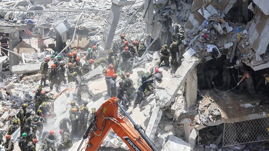 Equipes de resgate trabalham em um local de impacto após um ataque de míssil do Irã, em Bat Yam, Israel , 15 de junho de 2025