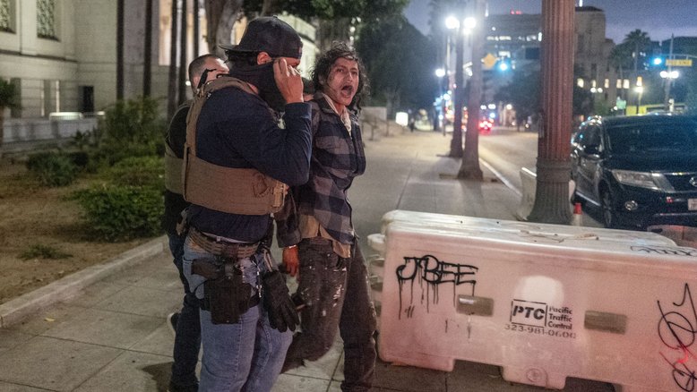 Policiais prendem um homem durante toque de recolher em Los Angeles