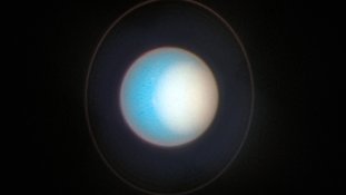 Nesta imagem, feita em novembro de 2022, o Polo Norte de Urano apresenta uma névoa fotoquímica espessa. Várias pequenas tempestades podem ser vistas perto da borda da névoa polar. O Telescópio Espacial Hubble tem monitorado o tamanho e o brilho da calota polar norte, que fica mais brilhante a cada ano. Os astrônomos estão desvendando múltiplos efeitos — da circulação atmosférica, das propriedades das partículas e dos processos químicos — que controlam como a calota polar atmosférica muda com as estações. Também na imagem, vê-se seu tênue anel, que circunda o planeta quase verticalmente.