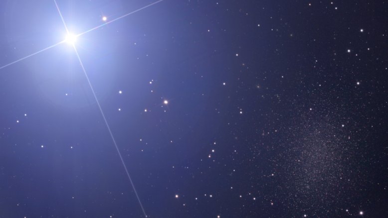 A estrela no canto superior esquerdo é tão brilhante que, às vezes, é difícil notar a galáxia no canto inferior direito. Tanto a estrela, Regulus, quanto a galáxia, Leo I, estão na direção da Constelação de Leão. Regulus faz parte de um sistema estelar múltiplo, com uma estrela dupla companheira, visível no canto superior direito da jovem estrela da sequência principal. Leo I é uma galáxia anã esferoidal, no Grupo Local de galáxias, onde estão também a nossa Via Láctea e a Galáxia de Andrômeda (M31). Regulus está localizada a cerca de 75 anos-luz de distância, mas Leo I fica a cerca de 800 mil anos-luz de distância
