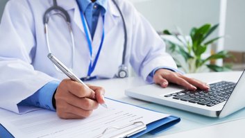 maos-da-medica-irreconhecivel-escrevendo-no-formulario-e-digitando-no-teclado-do-laptop-1