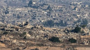 Foto a partir do sul de Israel mostra veículos militares israelenses e prédios destruídos na Faixa de Gaza, em 6 de julho de 2025 - AFP