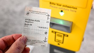 Um bilhete para quatro viagens da Autoridade de Transportes de Berlim-Brandemburgo em frente a uma máquina de bilhetes