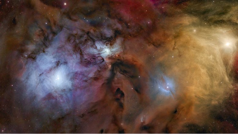 Por que o céu perto de Antares e Rho Ophiuchi é tão colorido, mas empoeirado? As cores resultam de uma mistura de objetos e processos. A poeira fina, iluminada pela luz das estrelas, produz nebulosas de reflexão azuis. Nuvens gasosas, cujos átomos são excitados pela luz ultravioleta das estrelas, produzem nebulosas de emissão avermelhadas. Nuvens de poeira iluminadas por trás bloqueiam a luz das estrelas e, portanto, parecem escuras. Antares, a supergigante vermelha localizada na Constelação de Escorpião, ilumina as nuvens amarelo-avermelhadas, no canto superior direito da imagem. O sistema estelar Rho Ophiuchi situa-se no centro da nebulosa de reflexão azul à esquerda