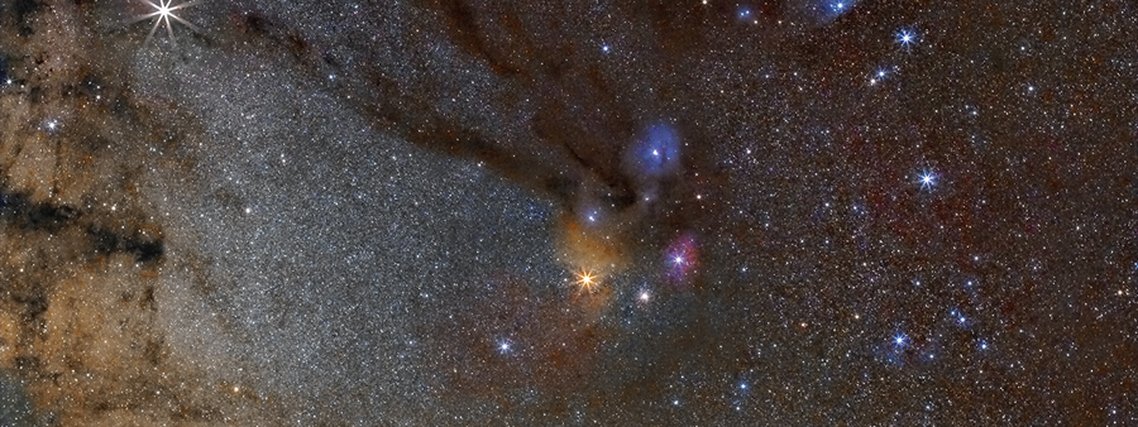 Conectando a Nebulosa do Cachimbo à estrela brilhante Antares, na Constelação de Escorpião, há uma nuvem escura e fluida apelidada de Rio Escuro. A turbidez do Rio Escuro é causada pela absorção da luz estelar de fundo pela poeira, embora a nebulosa contenha principalmente hidrogênio e gás molecular. Antares, a estrela brilhante que aparece amarela logo abaixo do centro da imagem, está inserida nas nuvens coloridas da nebulosa Rho Ophiuchi. O Rio Escuro, retratado acima no canto superior esquerdo, abrange mais de 20 vezes o diâmetro angular da Lua e está a cerca de 500 anos-luz de distância. Outros tipos de nebulosas visíveis aqui incluem a nebulosa de emissão vermelha e a nebulosa de reflexão azul