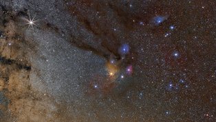 Conectando a Nebulosa do Cachimbo à estrela brilhante Antares, na Constelação de Escorpião, há uma nuvem escura e fluida apelidada de Rio Escuro. A turbidez do Rio Escuro é causada pela absorção da luz estelar de fundo pela poeira, embora a nebulosa contenha principalmente hidrogênio e gás molecular. Antares, a estrela brilhante que aparece amarela logo abaixo do centro da imagem, está inserida nas nuvens coloridas da nebulosa Rho Ophiuchi. O Rio Escuro, retratado acima no canto superior esquerdo, abrange mais de 20 vezes o diâmetro angular da Lua e está a cerca de 500 anos-luz de distância. Outros tipos de nebulosas visíveis aqui incluem a nebulosa de emissão vermelha e a nebulosa de reflexão azul