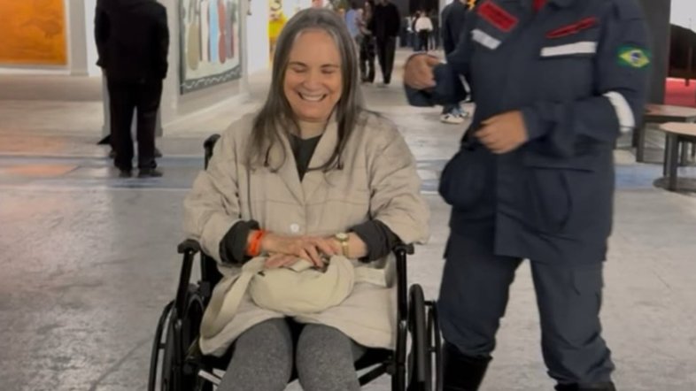 Regina Duarte deixa evento de cadeira de rodas